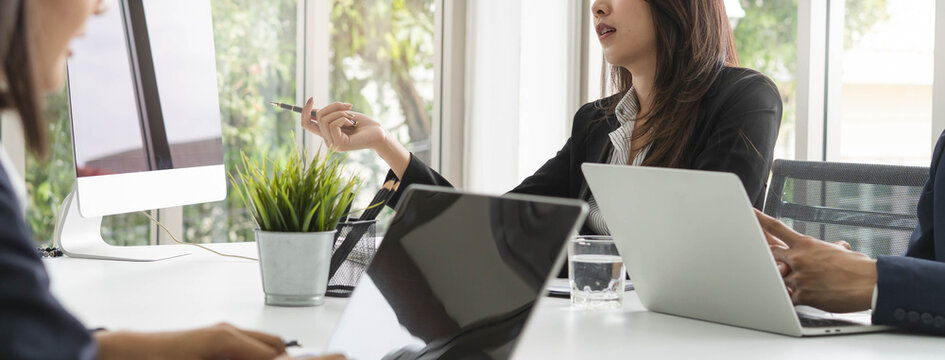 Group of employees meeting and discussing in conference room to share ideas.