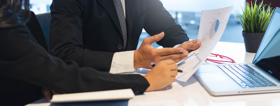 financial advisory services. Asian advisor showing plan of investment to clients in the consultancy office.
