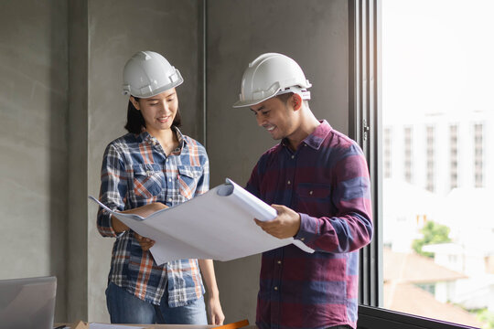 two architect look at blueprint and planning to renovation room.