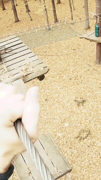 Person POV walk on wooden boxes between trees in adventure park