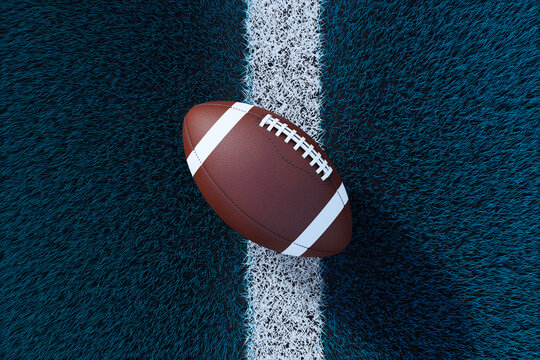 American football ball lying on textured turf field with white line, showing clean oval equipment for sport play and modern branding concept. 3D Rendering