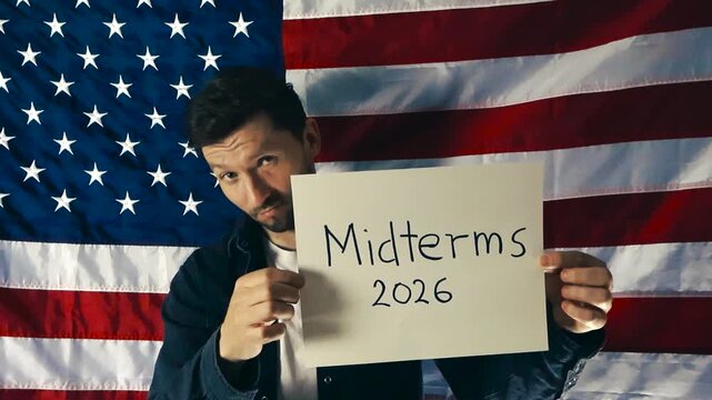 American Man Holding a Midterms 2026 Sign in Front of the United States Flag During an Election Campaign