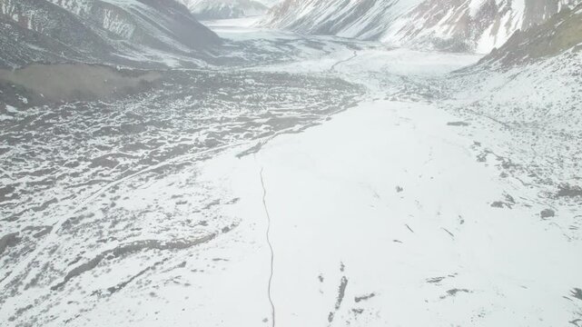 Drone view narrow winding path lead to Renlongba Glacier in snow capped mountain in Baxoi County, Qamdo Prefecture, Tibet, China, high angle view of Qinghai-Tibet Plateau, 4k real time travel footage