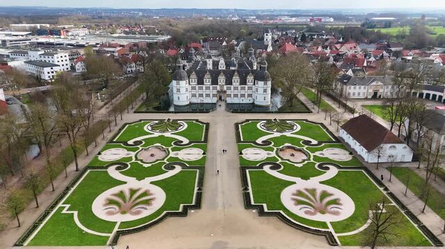 Drone view of the formal baroque garden leading to Schloss Neuhaus water castle in Paderborn, North Rhine-Westphalia, Germany.