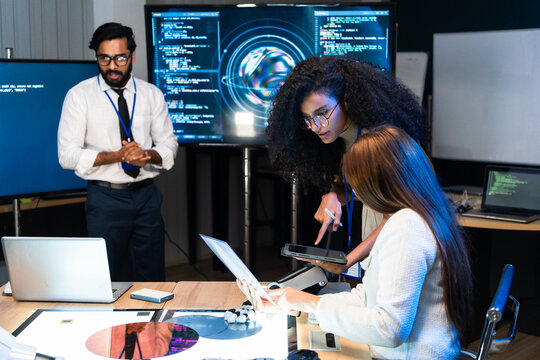 Tech team engineer analyze AI algorithm data on tablet screen and laptop. Engineer developer review artificial intelligence program code in semiconductor microchip wafer hardware laboratory