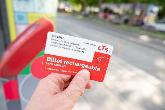 Holding tram and bus day ticket in hand, pubilc transportation, Strasbourg, Alsace in France, tramway in the city, infrastructure, CTS tramline