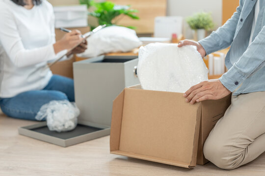 Moving house, relocation. Couple help set and move furniture for new apartment, inside the room was a cardboard box contain personal belongings. move in the new apartment or condominium