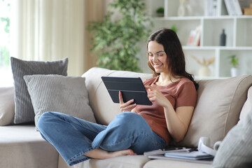 Fototapeta premium Happy young student watching online content on digital tablet