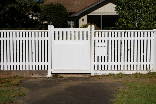 White picket fence and white front gate and mailbox