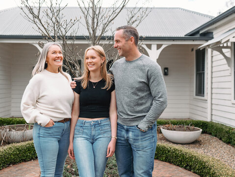 Happy family standing in the front yard of their new home