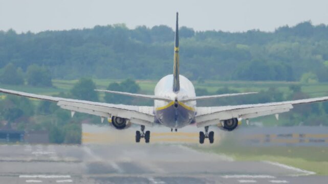 Airplane landing on runway with reduced visibility and wet surface