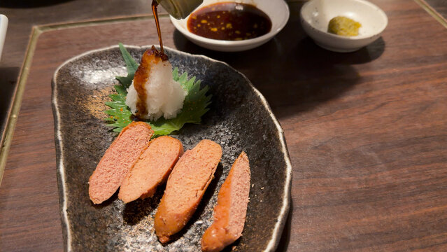 Sliced Mentaiko Roe with Grated Daikon and Sauce Being Poured