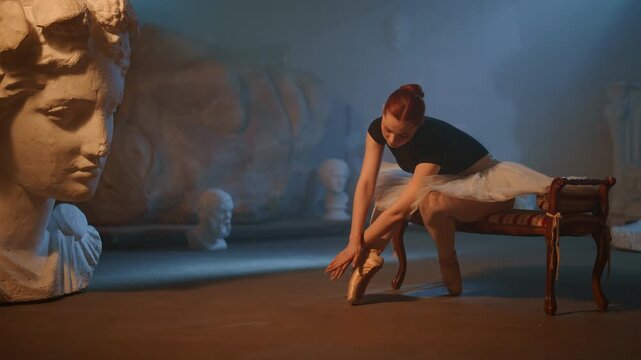 Tender ballerina rehearsing alone in unusual rehearsal hall in museum in night. Talented beautiful ballerina moving hands slowly and tenderly, hobby and self-expression by art, classic choreography