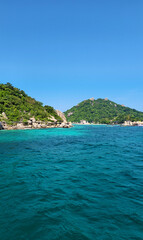Fototapeta premium Koh Nang Yuan Island seen from the sea with clear turquoise water and lush green hills, Surat Thani, Thailand, Southeast Asia.