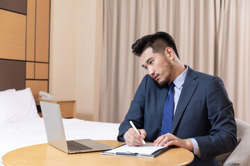 Fototapeta premium Businessman Working in Hotel Room on Business Trip