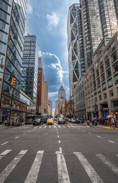 New york, usa august 20,2024. Urban street scene in manhattan, new york city, featuring the hearst tower, modern skyscrapers, bustling traffic, and pedestrians
