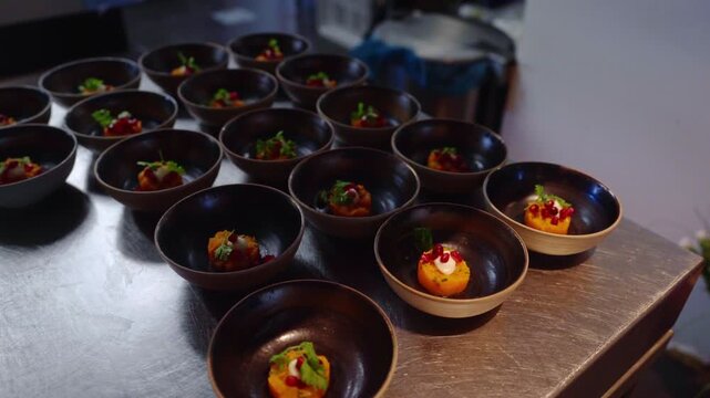 Delicious taster food inside a beautiful black bowl ready to serve in a luxurious star restaurant, vegetables, pomegranate topping.