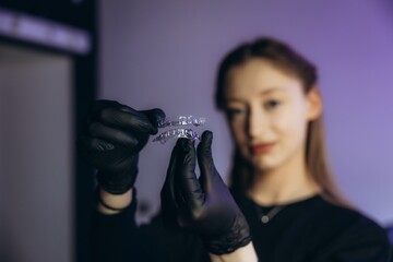 Dentist holding transparent aligners for orthodontic correction © Roman