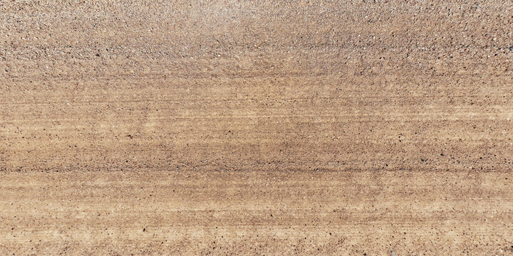top view of gravel road surface with tractor tire tracks in countryside