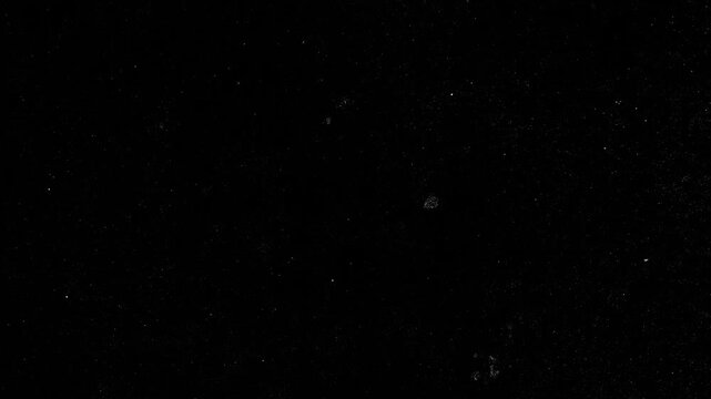 Video effect.Stop motion vintage black film grain texture with dust and scratches, retro grunge background for design, photo overlay and creative projects ,A dark, textured surface is displayed.