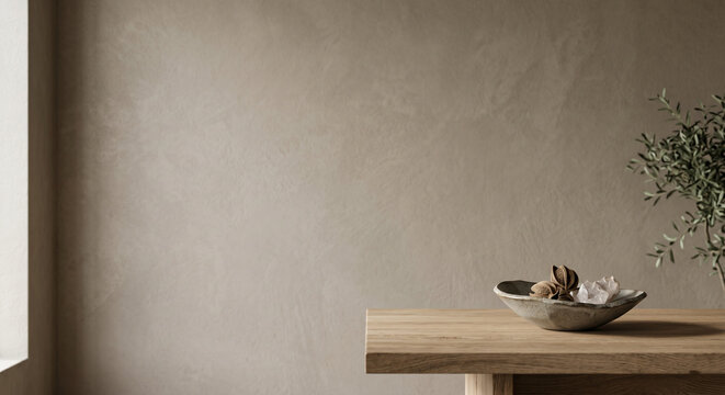 Minimalist interior with a rustic ceramic bowl on a wooden table against a textured plaster wall
