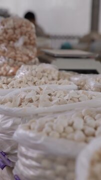 Close up view of traditional kurt displayed for sale at an authentic Uzbek bazaar. Assortment of dried fermented dairy snacks in different shapes and sizes presented at a local market stall