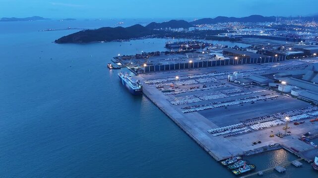 major commercial port with Ro-Ro ships, container vessels, and a massive automotive logistics parking lot. Global trade, maritime transport, and supply chain concept.	

