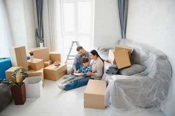 Family moving to new home unpacking living room
