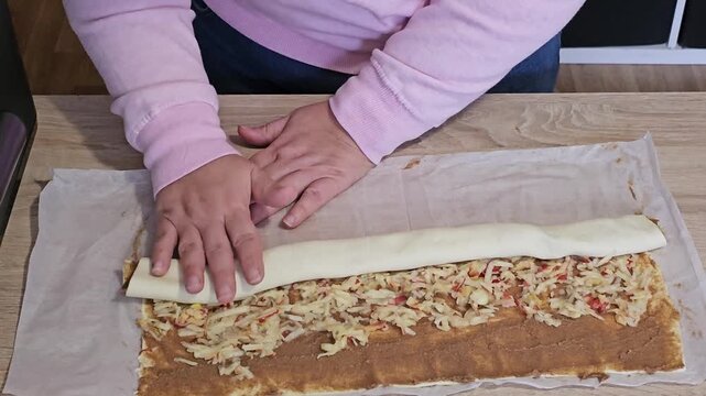 Woman's hands rolling homemade apple strudel dough