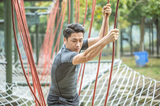 Man training on outdoor rope obstacle course