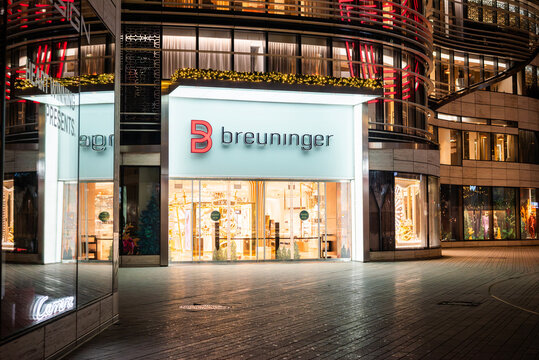 Dusseldorf, Germany, December 24, 2025, Illuminated entrance of the luxury department store Breuninger at night with festive Christmas window displays
