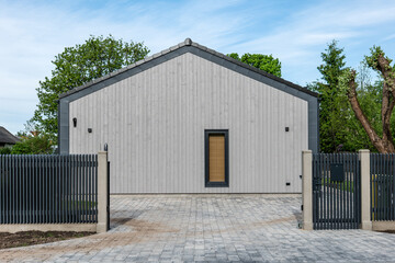 Obraz premium Modern Wooden House Exterior With Minimalist Architecture and Black Metal Fence
