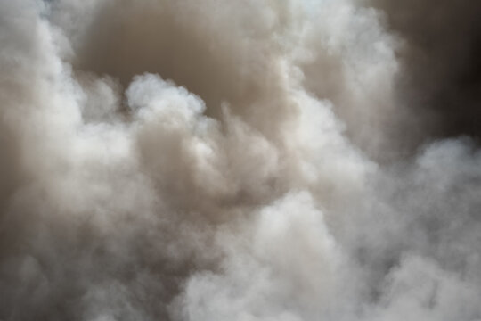 Toxic black smoke from fire against sky, burning plastic. Billowing cloud of smoke. A thick smoke covering part of the sky