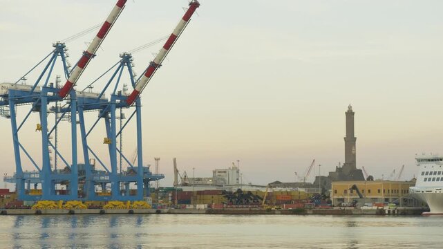 Genoa lighthouse Lanterna and port cranes at dawn, Italy