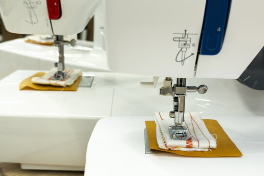 White sewing machine with fabric samples under presser foot and needle for craft education