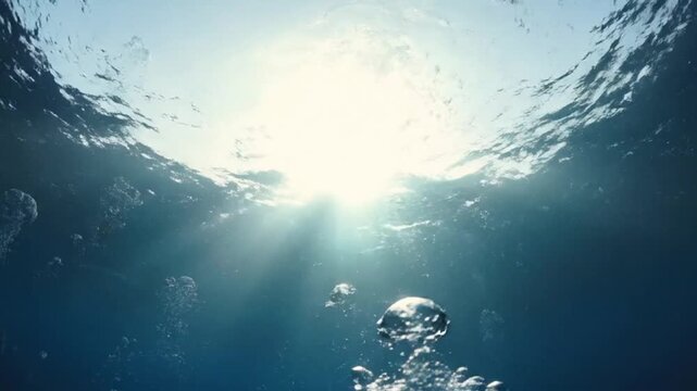 Sunlight streams through the water with bubbles rising to the surface above