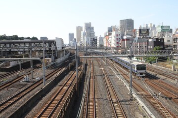 Fototapeta premium High angle view of multiple railway tracks and a running train in Tokyo.