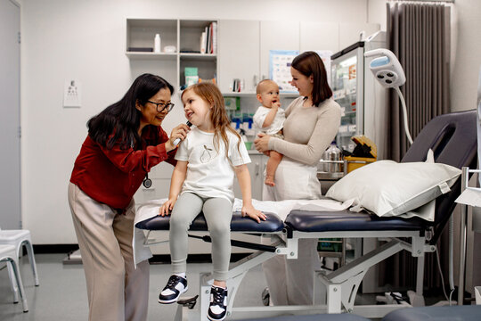 Healthcare professional conducting paediatric ear check‑up to a young girl