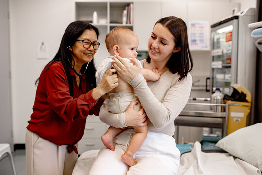 Paediatrician doctor examining the baby boy using a stethoscope