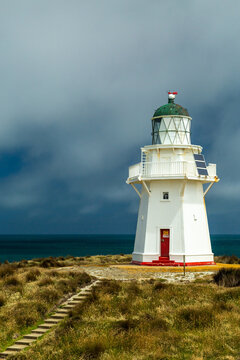 Storms approaching Waipapa Point Lighthouse atop a coastal hill