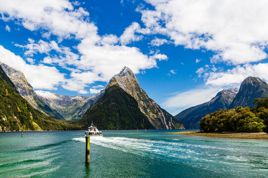 Boat travelling into a body of water with mountains in background