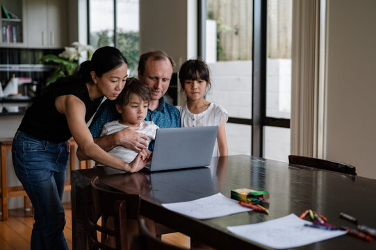 People gathered around a laptop, enjoying time together in a family living space