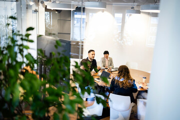 Diverse business team collaborating and brainstorming in a modern office meeting room, discussing...