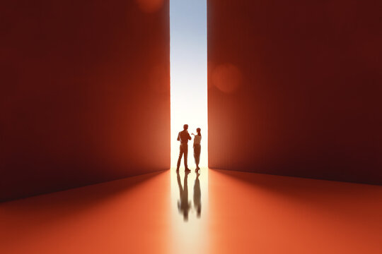 Silhouettes of Two People Discussing Ideas in Abstract Corridor with Dramatic Lighting