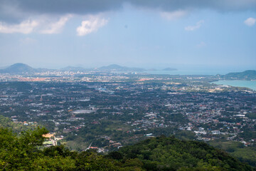 Obraz premium Panoramic aerial view of Phuket city with tropical coastline, ocean bays and dramatic cloudy sky.