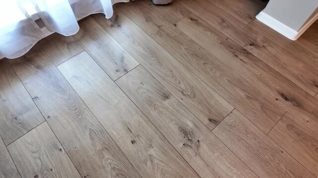 Natural wood laminate parquet floor. Room with laminate in new apartmen. Cozy home interior, modern design