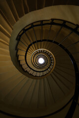 Fototapeta premium Elegant Spiral Staircase View from Below in a Historical Building with Fibonacci Pattern and Bright Light at the Top