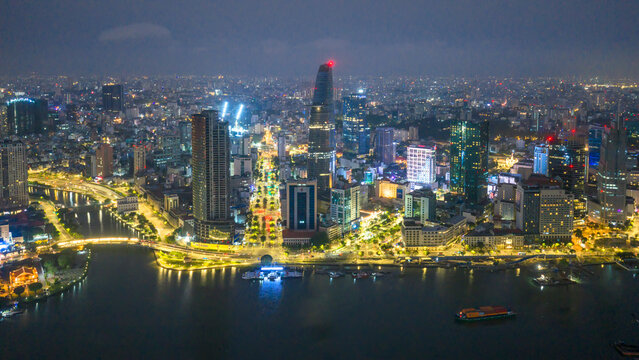 Stunning aerial night view of Ho Chi Minh City, Vietnam featuring the illuminated skyline, Saigon River, modern skyscrapers, vibrant city lights, and the dynamic urban landscape of Vietnam's