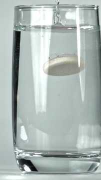 An aspirin tablet falls into a glass of water. Filmed on a high-speed camera at 1000 fps. High quality FullHD footage