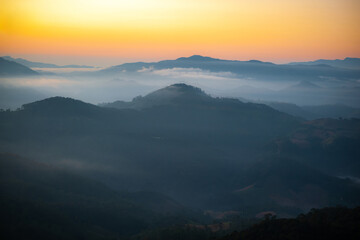 Obraz premium A picture of mountains covered in mist in the morning.